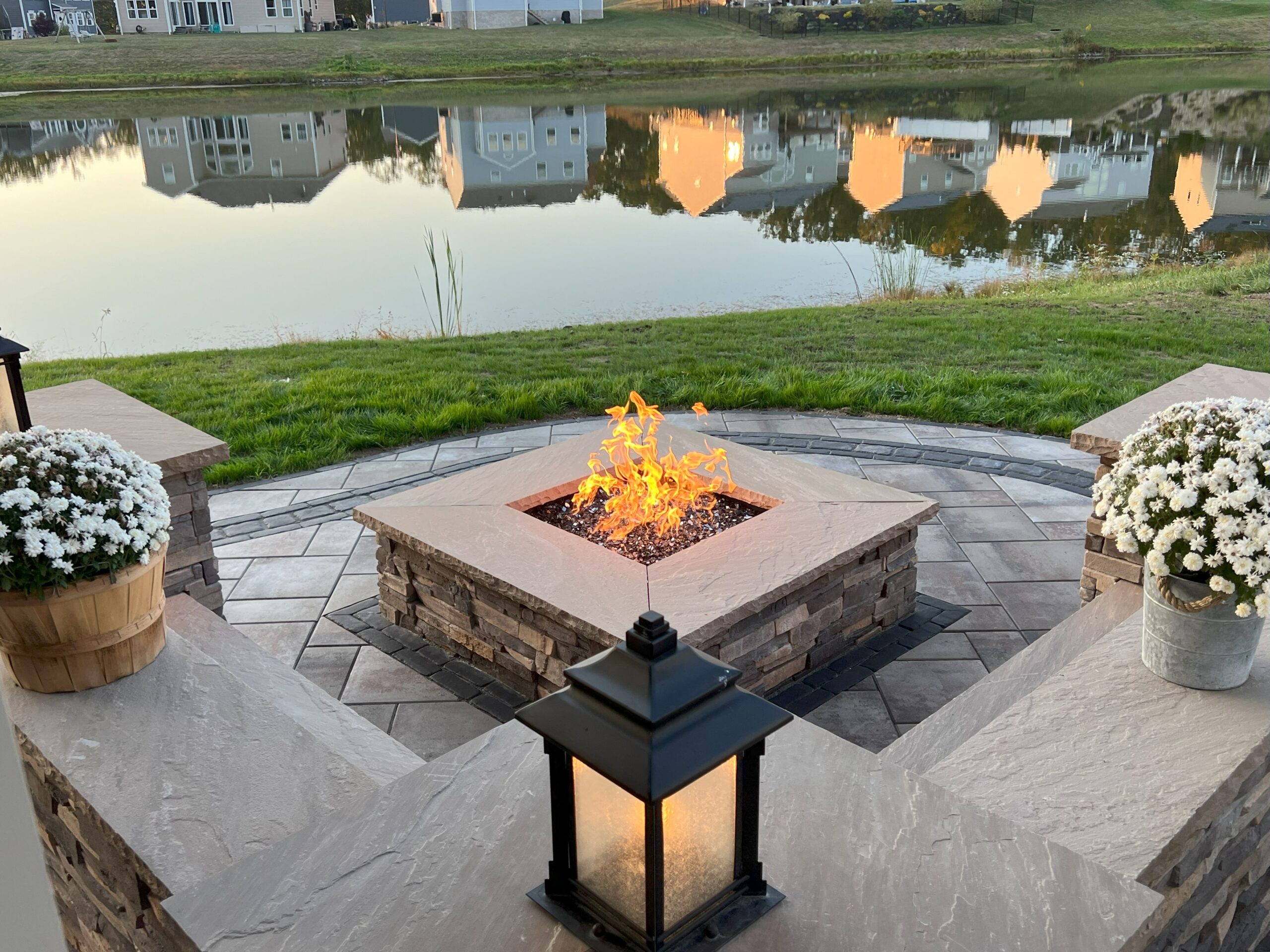 Libertystone outdoor area featuring a firepit, pavers, and a seating/garden wall